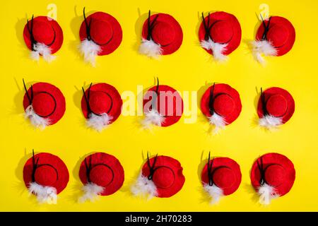 Quindici cappelli di lana feltrati con una piuma su sfondo giallo Foto Stock
