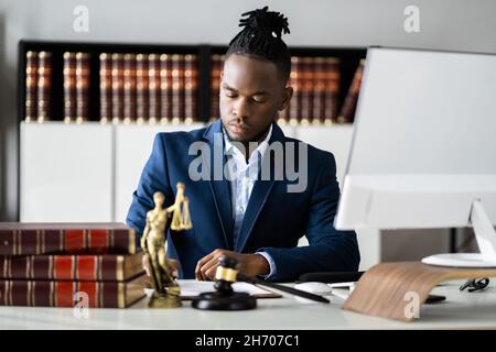 Documenti di lettura dell'avvocato alla scrivania in Courtroom Foto Stock