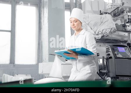 Banner per l'industria alimentare. Operaio di fabbrica che ispeziona la cisterna della linea di produzione in della fabbrica di caseificio. Foto Stock