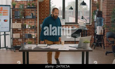 I dipendenti si sono preparati a un affare di successo nell'ufficio startup. Un uomo d'affari motivato che si prepara a una riunione su un importante contratto e un importante successo di carriera su un notebook Foto Stock