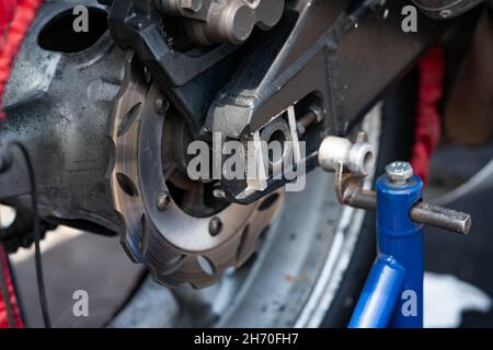 vista di una ruota posteriore del motociclo e del disco del freno. Foto Stock