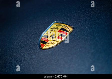 Riga, Lettonia, Sep 24, 2021: Vista del logo della società Porsche sul cofano della vettura blu, primo piano Foto Stock