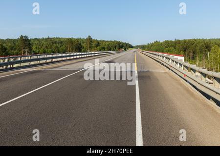 Strada asfaltata. Ponte automobilistico sulla ferrovia in Siberia. Foto Stock