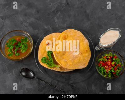 Pane piatto di mais fatto in casa cilantro verde salsa di pomodoro. Tortilla messicana Taco Quesadilla vegetale fatta a mano. Tradizionale indiano Makki ki roti pane top Foto Stock