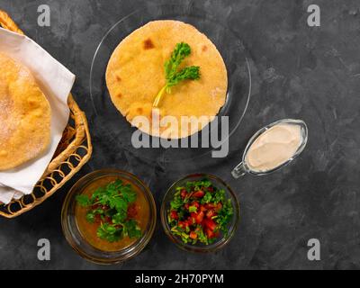 Pane piatto di mais fatto in casa cilantro verde salsa di pomodoro. Tortilla messicana Taco Quesadilla vegetale fatta a mano. Tradizionale indiano Makki ki roti pane top Foto Stock