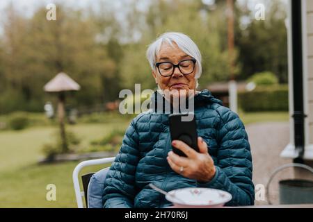 Donna sorridente usando il telefono Foto Stock