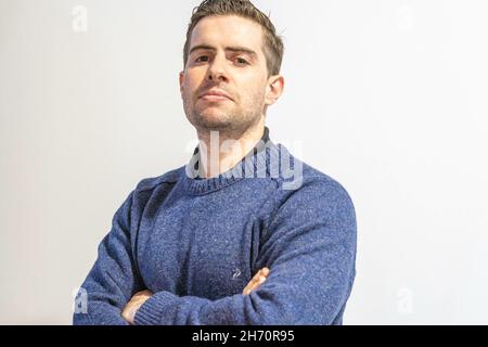 Primo piano dell'uomo in un maglione blu isolato su sfondo bianco. Foto Stock