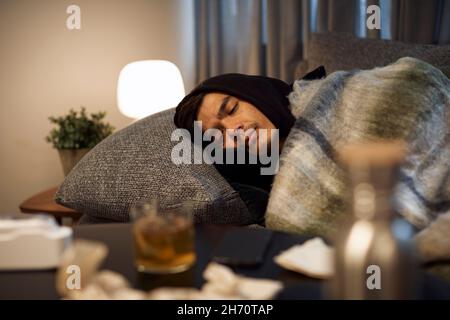 Ill young man sleeping on sofa Foto Stock