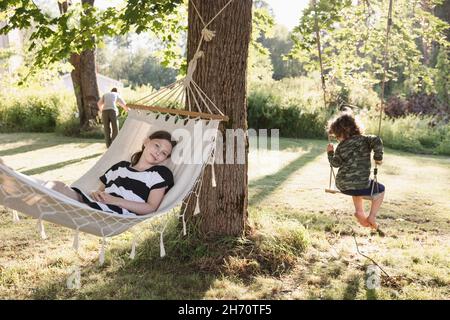 Ragazza e ragazzo su amaca e swing Foto Stock