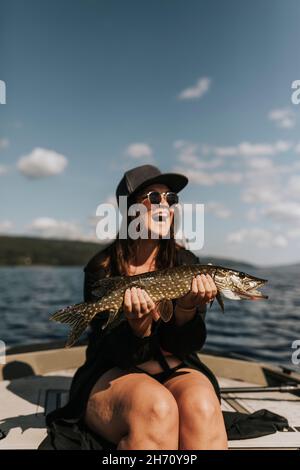 Donna felice che tiene il pesce Foto Stock