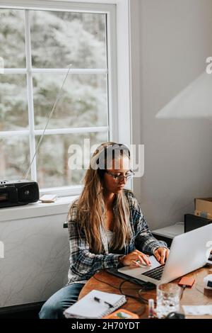 Donna con notebook in cucina Foto Stock