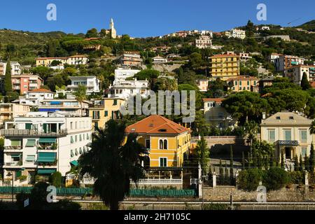 Vista sulla collina che domina la città costiera di Alassio con le vecchie case vacanze e la chiesa di Santissima Annunziata in cima in estate, Alassio Foto Stock