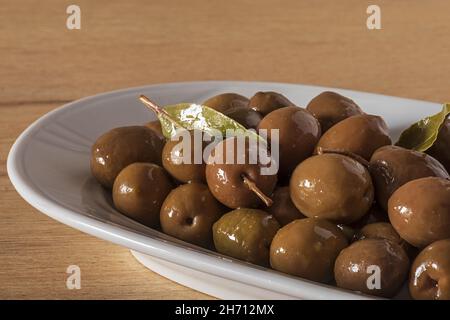 condite di olive nel piatto ovale Foto Stock