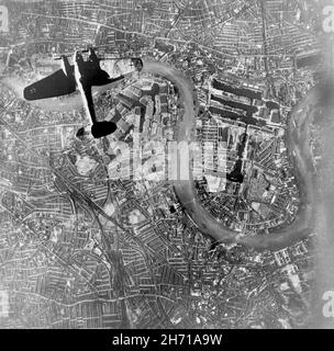 LONDRA, INGHILTERRA, Regno Unito - 07 settembre 1940 - Un tedesco Luftwaffe Heinkel He 111 bombardiere che vola su Wapping e l'Isola dei Dogs nell'estremità orientale di Londra Foto Stock