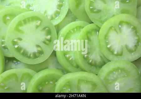 uno sfondo con pomodori verdi Foto Stock