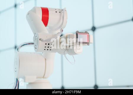 Braccio del robot con sensore di immagine a matrice CCD e CMOS nel manipolatore. Concetto sul tema della visione artificiale e del riconoscimento del modello Foto Stock