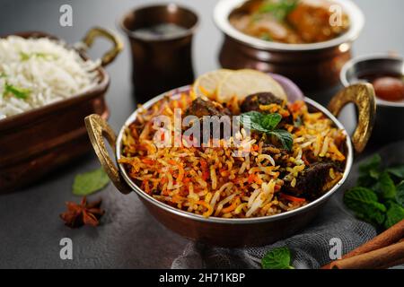 Indian veg non veg meal thali - mutton biryani, raita, malai kofta, riso basmati, e gulab jamun, messa a fuoco selettiva Foto Stock