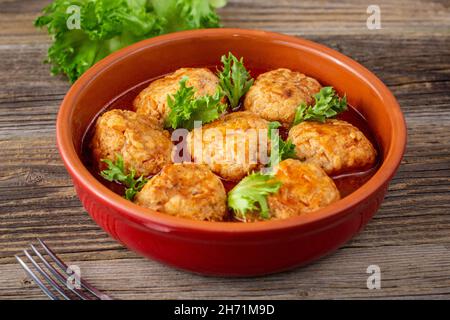 Polpette in salsa di pomodoro in una ciotola su un tavolo di legno. Cibo gustoso per la cena. Foto Stock