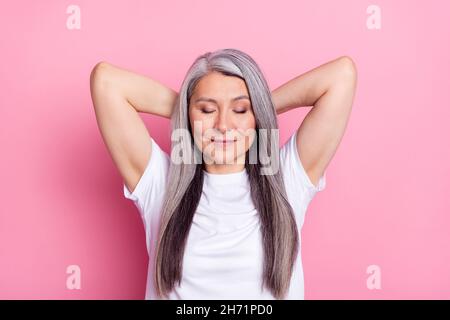 Ritratto fotografico di nonna con capelli grigi stanchi riposarsi a pausa isolato su sfondo color rosa pastello Foto Stock