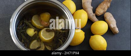 Pentola piena di limoni bolliti e zenzero per l'influenza Foto Stock