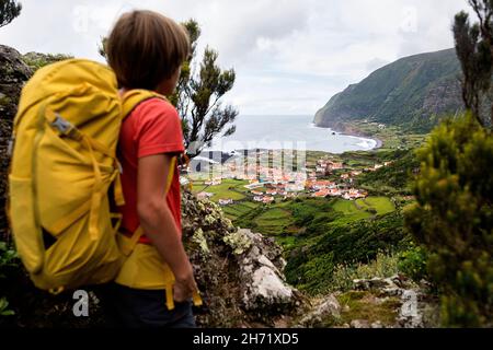 Boy Lookinga t la vista di Faja Grande sul sentiero per Vigia, vecchio avvallamento dei whalers sull'isola di Flores, arcipelago delle Azzorre (Portogallo, Europa Foto Stock