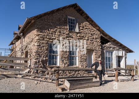 La guida cowboy di fronte al vecchio Stratford Hotel su Avon Street nella città fantasma di Shakespeare, New Mexico. Foto Stock