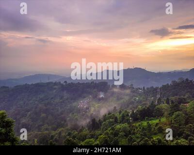 spettacolare tramonto arancione cielo sopra la catena montuosa e la foresta verde in serata dalla collina immagine è preso al mirik darjeeling west bengala india. Foto Stock