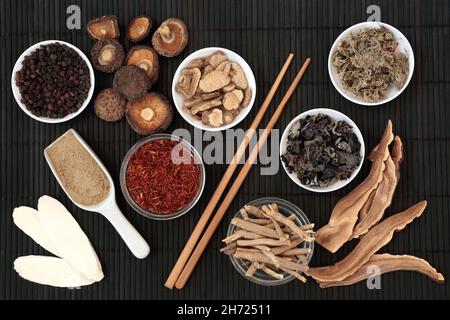 Preparazione di erbe e spezie cinesi per la medicina tradizionale delle piante di erbe. Rimedi naturali alternativi di guarigione. Concetto di assistenza sanitaria. Su bambù. Foto Stock