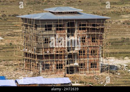Workers working on an apartment building under construction in Thimphy with bamboo scaffolding. Foto Stock