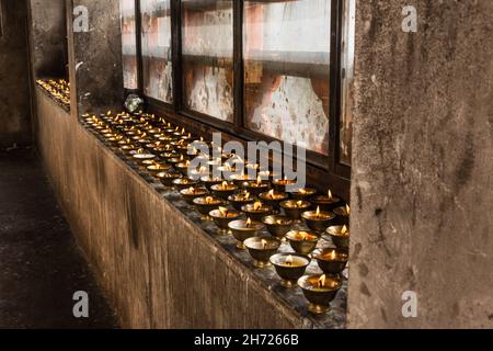 Caramelle votive al burro di yak che bruciano al monastero di Dechen Phodrang a Thimphu, Bhutan. Foto Stock