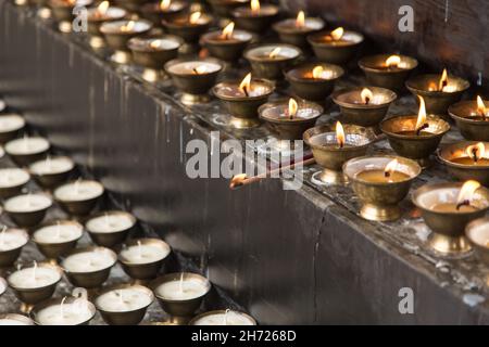 Caramelle votive al burro di yak che bruciano al monastero di Dechen Phodrang a Thimphu, Bhutan. Foto Stock
