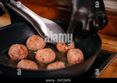 Primo piano palline di carne friggere su una padella calda Foto Stock