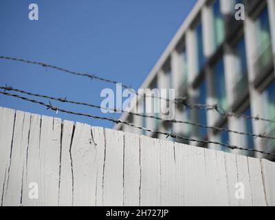 Recinzione in legno e ferro di fronte ad un edificio di uffici a più piani Foto Stock