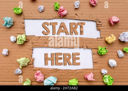 Il segno di scrittura della mano inizia qui. Idea di affari che dice qualcuno questo è punto di inizio per andare da a destinazione che forma nuovi pensieri scoprire idee fresche Foto Stock