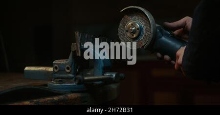 Primo piano utilizzare una macchina per il taglio di metalli o ferro e smerigliare i metalli su pezzi di ricambio in acciaio in officina Foto Stock