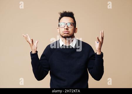 Ritratto di elegante uomo barbuto con annoiato di espressione, sembra dispiaciuto, essendo stanco di spiegare. Puzzled maschio doesnt sapere che cosa fare Foto Stock