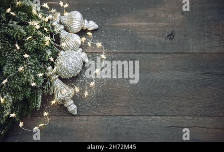 Decorazioni di Natale in argento ornamenti luci dorate su sfondo scuro Foto Stock