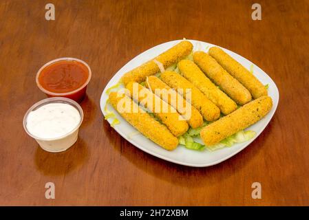 I bastoncini di mozzarella sono pezzi lunghi di mozzarella che vengono impanati o impanati e fritti. Spesso servito nei ristoranti come aperitivo Foto Stock