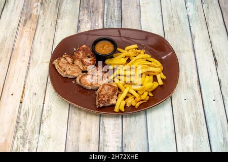 Grande porzione di filetto di maiale iberico alla griglia con patate fritte fatte in casa e salsa Foto Stock