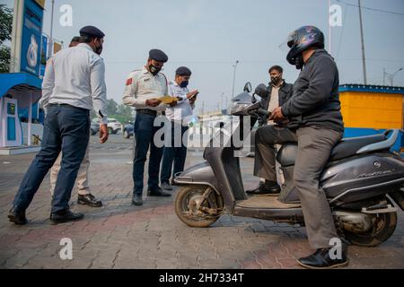 New Delhi, India. 19 Nov 2021. I funzionari del dipartimento dei trasporti di Delhi hanno visto controllare una motocicletta in una stazione di rifornimento.la polizia del traffico di Delhi sta facendo funzionare un'unità di applicazione 'inquinamento sotto controllo (PUC)' contro l'inquinamento dei veicoli a due ruote a Nuova Delhi come l'indice di qualità dell'aria di Delhi (AQI) è molto malsano dopo il festival Diwali. Credit: SOPA Images Limited/Alamy Live News Foto Stock