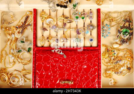 Una scatola di gioielleria aperta con gioielli in oro e platino e accessori da vicino Foto Stock