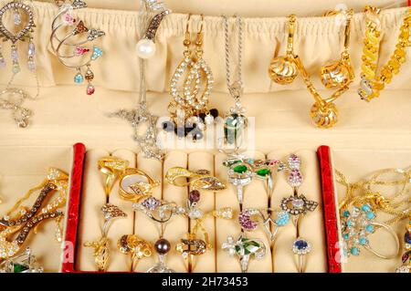 Una scatola di gioielleria aperta con gioielli e accessori in oro e platino, primo piano Foto Stock