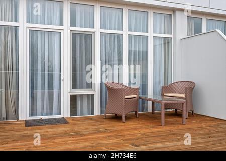 Terrazza con tavolo e poltrone con finestre panoramiche Foto Stock