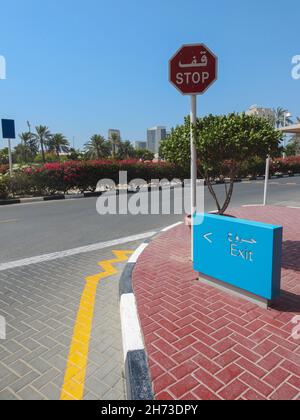 Incrocio con uscita e segnaletica di stop in lingua inglese e araba Foto Stock