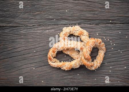 i bagel si spirano con semi di sesamo su sfondo di legno scuro Foto Stock