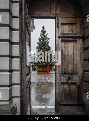 La vista del gigantesco albero di Natale a Covent Garden attraverso le porte della chiesa di St Paul a Londra. Foto Stock