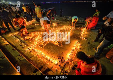 Varanasi, India. 19 Nov 2021. I devoti indù indiani illuminano le lampade mentre pregano a Dio alla vigilia di dev Deepavali.Dev Deepavali è il più grande Light Festival dell'India dove i devoti decorano la riva del fiume di Gange con milioni di lampade come parte del festival. Credit: SOPA Images Limited/Alamy Live News Foto Stock