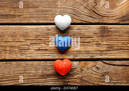 Cuori di colore della bandiera russa su sfondo di legno Foto Stock
