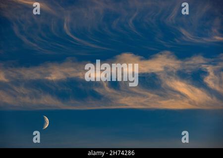 Cirrus nuvole con mezza luna Foto Stock
