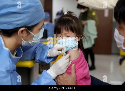 Shanghai, Cina. 20 Nov 2021. Una bambina di quattro anni riceve il vaccino COVID-19 in un sito di vaccinazione nel distretto di Xuhui di Shanghai, Cina orientale, 20 novembre 2021. Shanghai ha iniziato la vaccinazione COVID-19 per i bambini di età compresa tra i 3-5 e i 24 anni a partire da sabato. Credit: Liu Ying/Xinhua/Alamy Live News Foto Stock